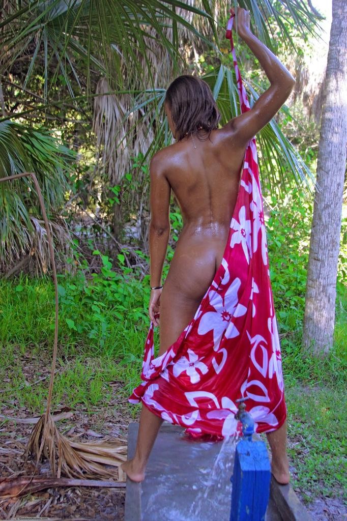 Well built ebony goddess is slinky and nude under tropical red wrap