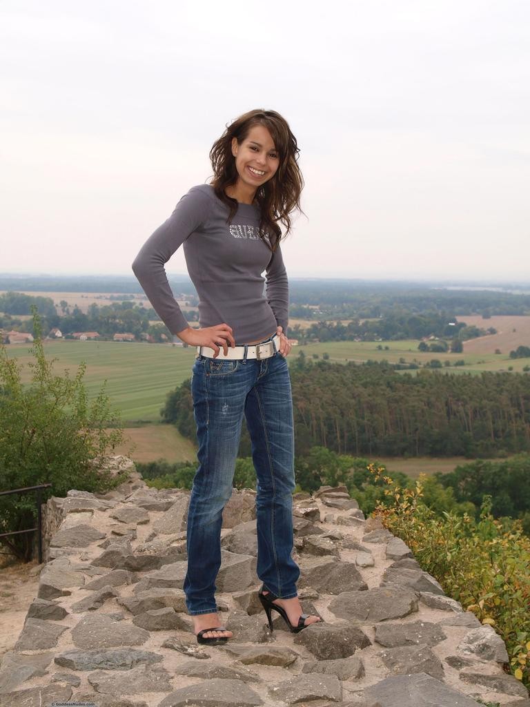 Sylvia slips out of her blue jeans and heels to stand proudly nude atop hill